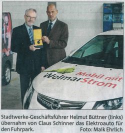 Bild: Helmut Büttner und Claus Schinner bei der Übergabe des Opel Ampera